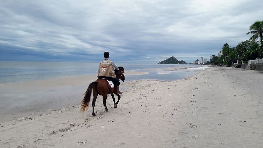 Family having fun horse riding at Hua Hin Beach in Thailand