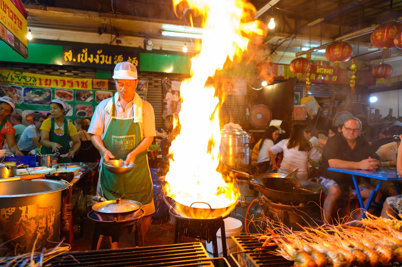 Busy Bangkok street food market with variety of Thai dishes